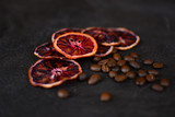 Beautiful and tasty background for design. Dried red orange slices with a coffee beans on a stone background. Cuisine wallpaper.