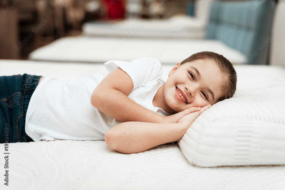 Smiling little girl lies on n orthopedic mattress in a furniture store. Smiling little girl lies on n orthopedic mattress in a furniture store.