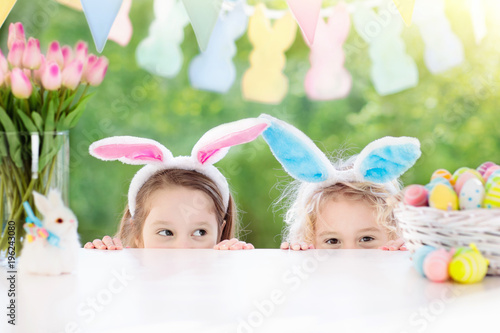 Kids with bunny ears and eggs on Easter egg hunt.