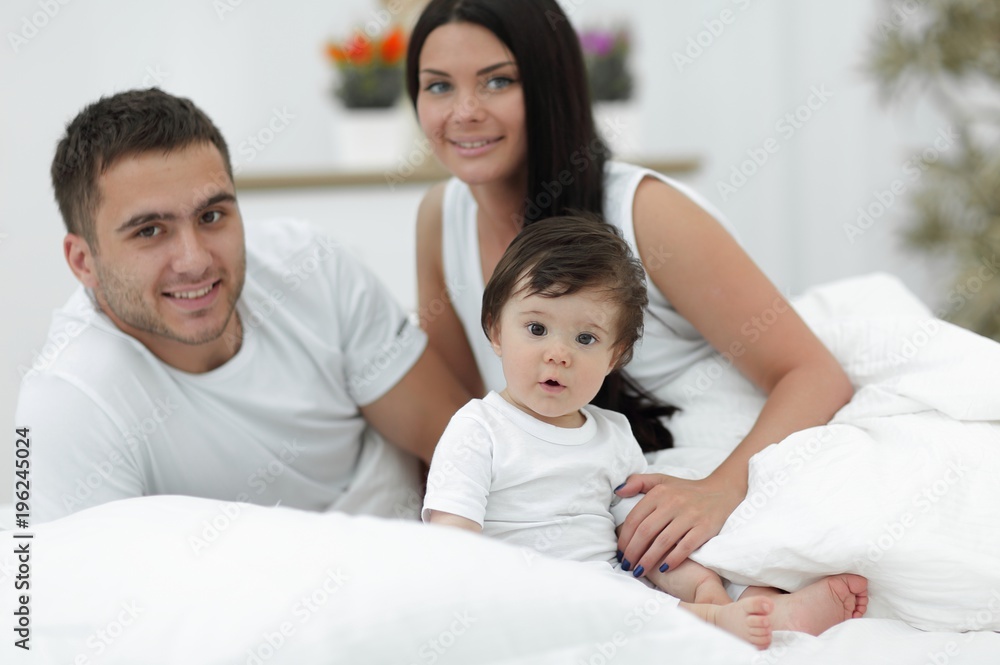 Cheerful family having fun together lying on a bed Cheerful family having fun together lying on a bed