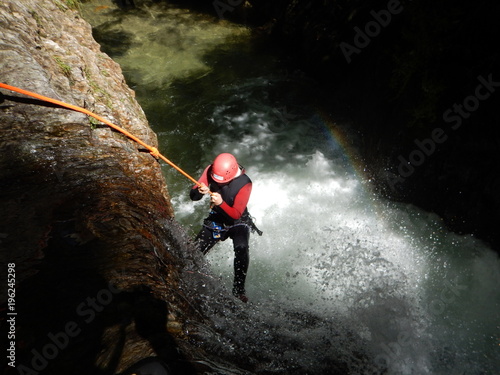 Canyoning Adventure: Young Courageous Girl Abseiling into a Canyon photo