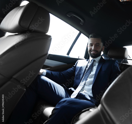 businessman talking on the phone while sitting in the back seat of his car © ASDF