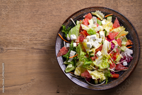 Grapefruit, tomato, lettuce and cucumber salad with feta cheese. Clean eating, healthy and diet food concept. View from above, top