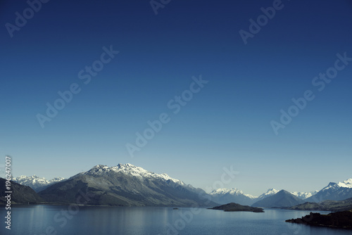 Paisaje de monta  as con picos nevados. Las monta  as se reflejan en un lago. Escena diurna  cielo azul y despejado. Nueva Zelanda.
