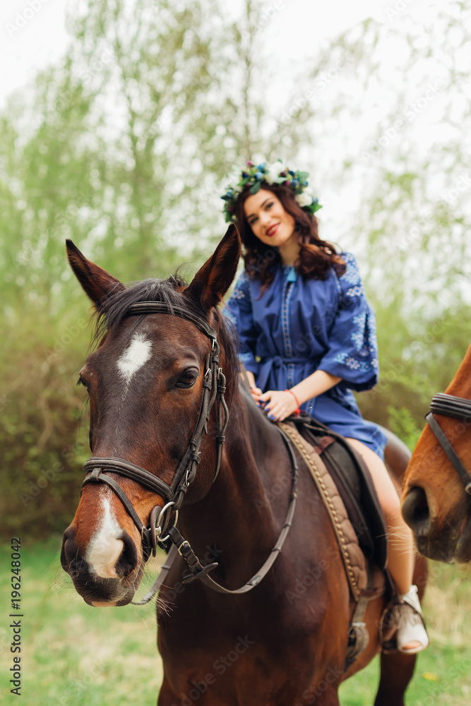 a brown horse with white spots on the head and a beautiful girl sitting on it a brown horse with white spots on the head and a beautiful girl sitting on it