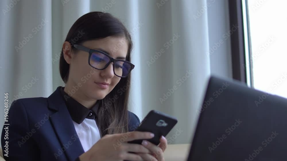 Young attractive woman in the suite sit with laptop and texting. Young attractive woman in the suite sit with laptop and texting.