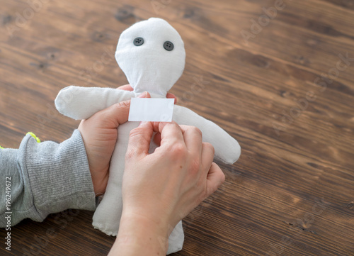 Frau sticht mit einer Nadel in eine Voodoo Puppe photo