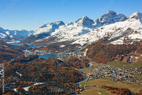 Blick über das Engadin in den Schweizer Alpen. Herbstlandschaft mit schneebedeckten Bergen, Wäldern, Seen und den Orten St. Moritz und Celerina in Graubünden, Schweiz