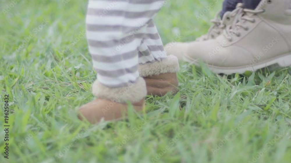 Baby boy feet learning how to walk with mom Baby boy feet learning how to walk with mom
