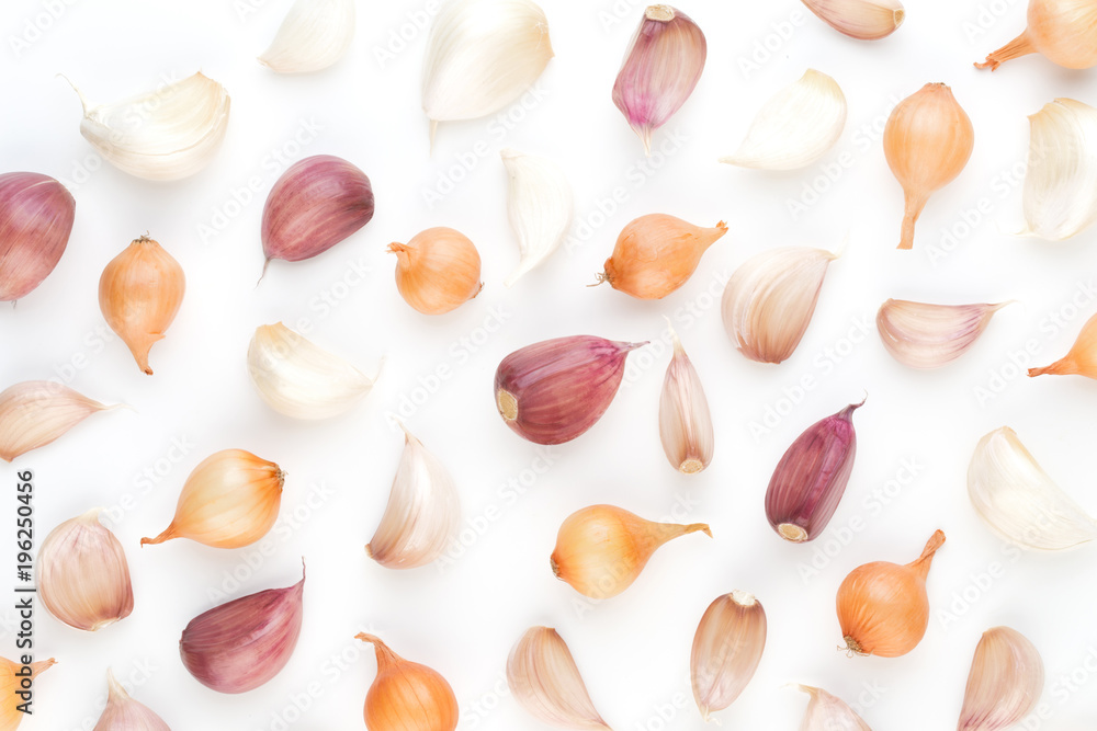 Onion and garlic isolated on white background, top view. Wallpaper abstract composition of vegetables.