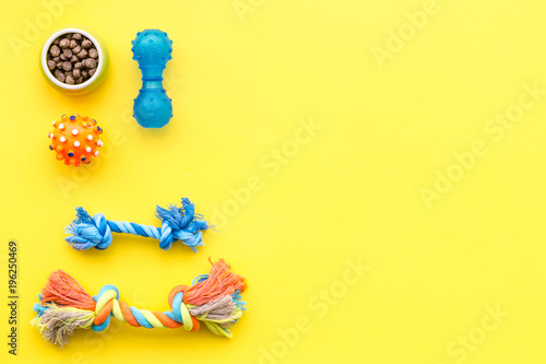 grooming equipment with brushes and toys for care and training pet yellow background top view mock up
