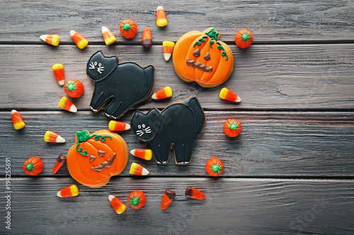 Halloween gingerbread cookies with candies on wooden table