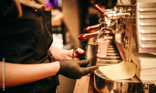 Barista women use jar pouring milk on hot coffee photo