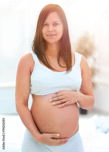 portrait of young pregnant woman on a light background. Free Download portrait of young pregnant woman on a light background. - GFXLoad