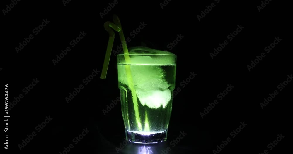 Slider shot. Rotating cocktail with ice in smoke on dark background. Club drinks concept. One glass of cocktail Slider shot. Rotating cocktail with ice in smoke on dark background. Club drinks concept. One glass of cocktail