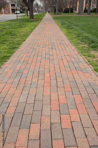 brick sidewalk lined street of campus and town