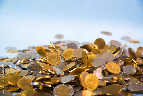 Falling coins money on blue background  business wealth concept.