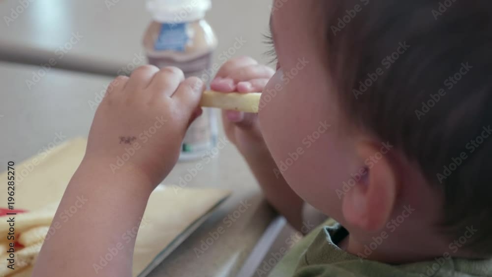 Young toddler eating chicken nuggets and french fries for lunch at fast food Young toddler eating chicken nuggets and french fries for lunch at fast food