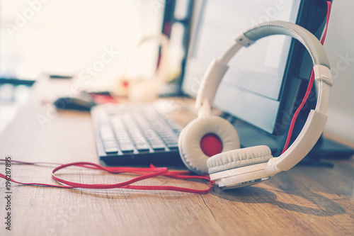 professional headphone in soft focus with blurred computer , vintage tone
