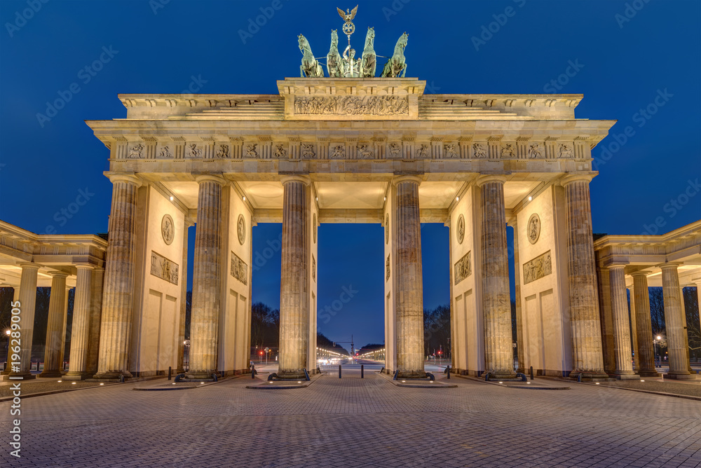 Obraz premium Słynny oświetlony Brandenburger Tor w Berlinie wczesnym rankiem