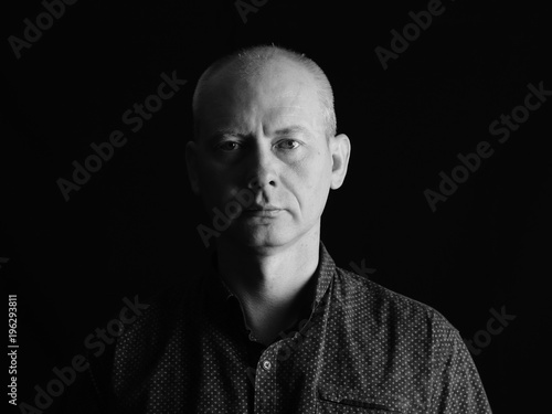 Portrait of serious man on dark background.