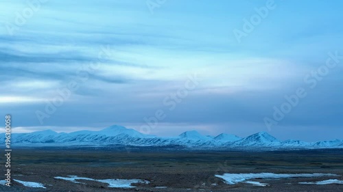 time lapse of cold steppe in tibet plateau and snow mountain at dusk, Qinghai Hoh Xil nature reserve, China photo