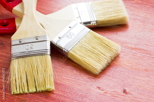 House renovation, paintbrushes on the old wooden background