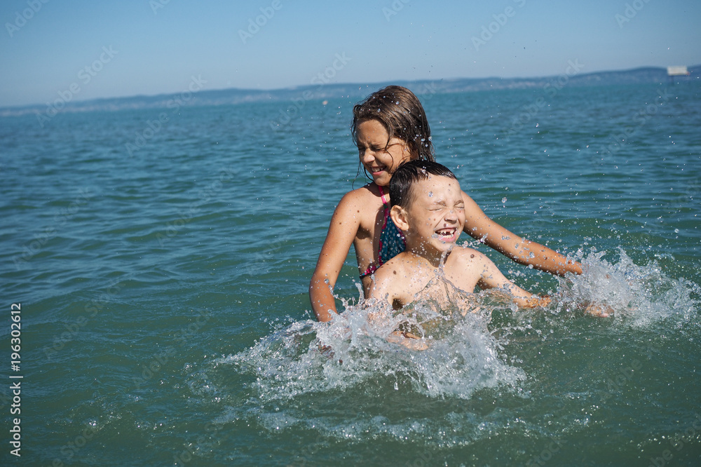 Little girl and littel boy playing in water Little girl and littel boy playing in water