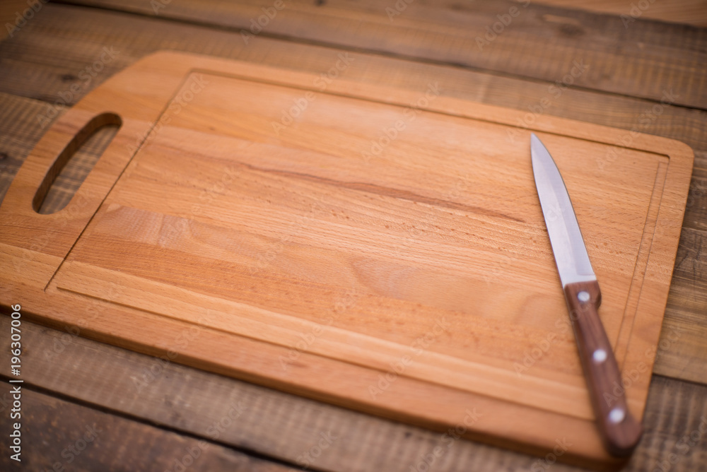 Wooden cutting board with knife. Place for text. Recipe design horizontal. Top view