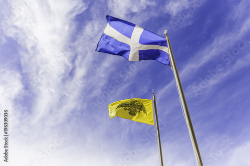 Greek and Byzantine flags waving on the air against cloudy sky photo