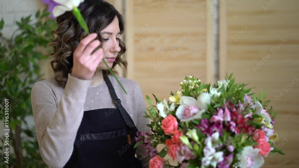 Female florist Arranging Flowers In Flower Shop Female florist Arranging Flowers In Flower Shop