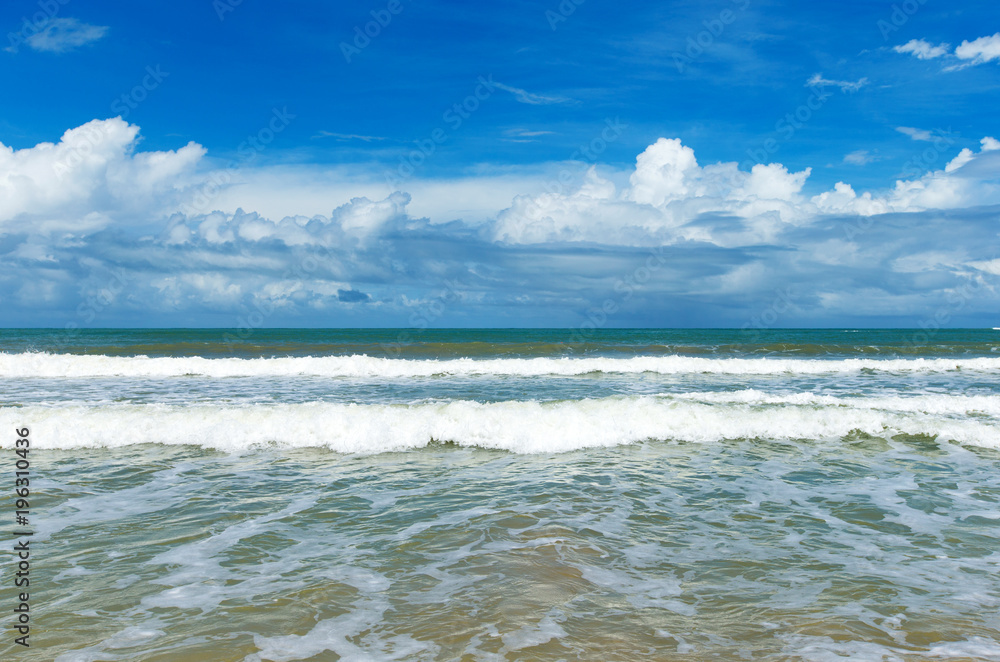 clouds on blue sky over calm sea with sunlight reflection