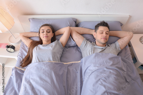 Young couple sleeping in be...