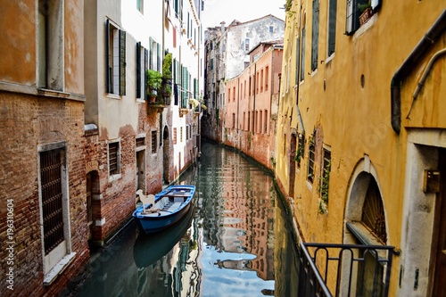 A Venetian canal with docked boats. Venice, Italy
