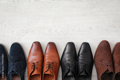 Different male shoes on wooden floor