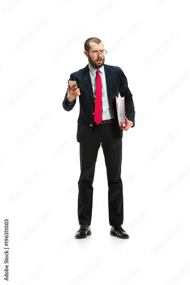 Angry businessman talking on the phone isolated over white background in studio shooting Angry businessman talking on the phone isolated over white background in studio shooting
