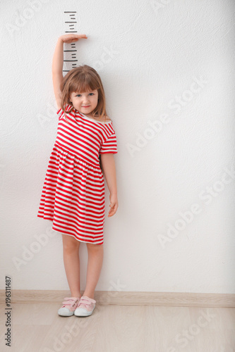 Cute little girl measuring ...