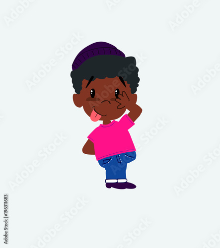 Black boy in a swimsuit sticks out his tongue in gesture of funny shyness.