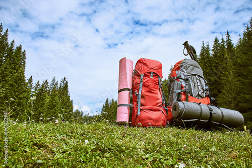 Backpacks in the mountains overlooking the mountains on the green grass. photo