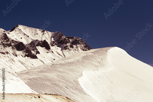 Rocky mountain range covered with snow. Retro toning photo