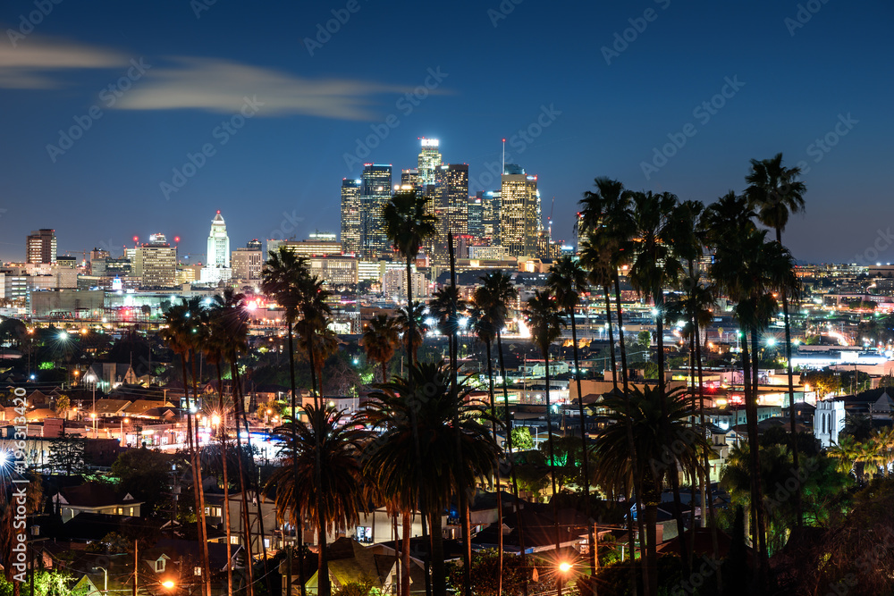 Obraz premium Piękna noc na panoramę centrum Los Angeles i palmy na pierwszym planie
