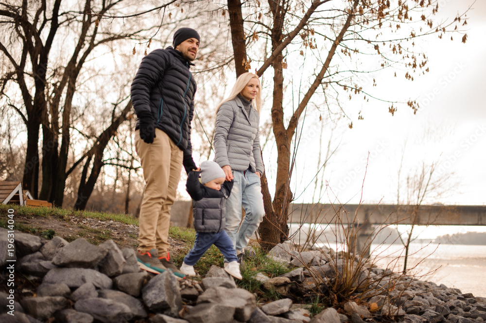 Young and happy family couple walking with the son Young and happy family couple walking with the son