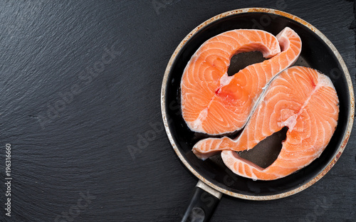 Fresh raw unprepared fish salmon or trout, steaks, in a frying pan, top view