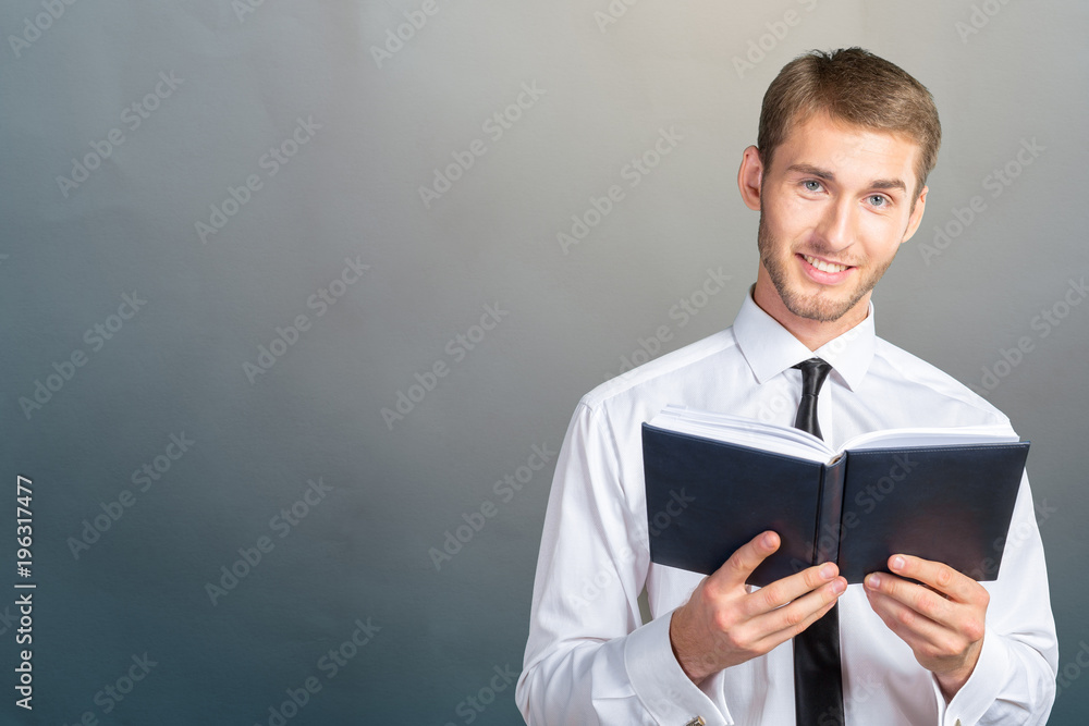 Handsome young business man reading a book Handsome young business man reading a book