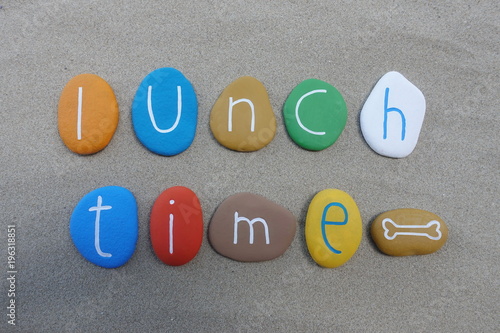 Lunch time, conceptual multicolored stones composition over beach sand
