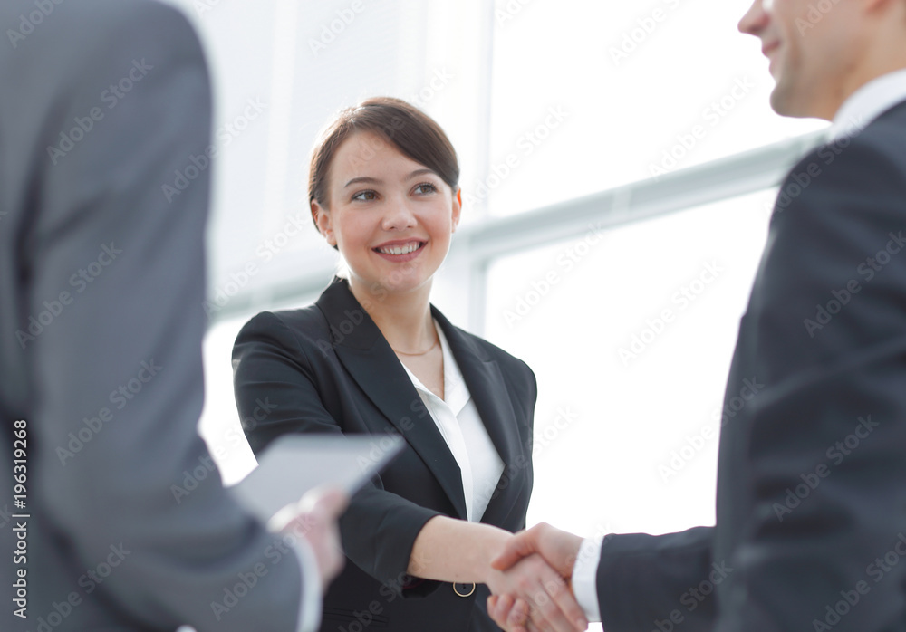 Businesswoman shaking hands with a businssman during a meeting Businesswoman shaking hands with a businssman during a meeting