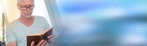Portrait of mature man reading a book  light effect