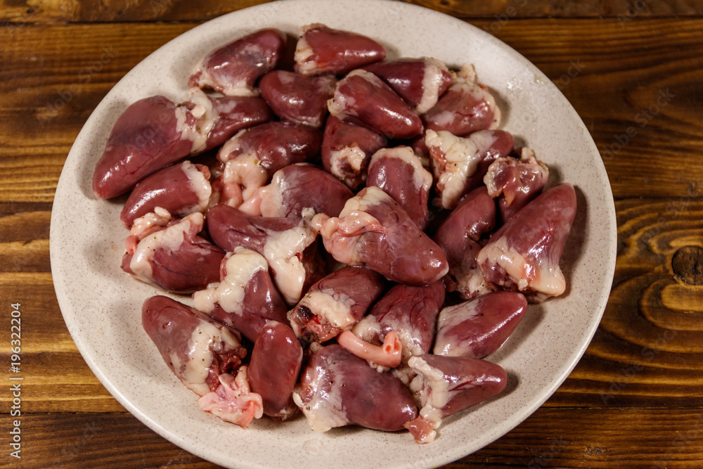 Raw chicken hearts on wooden table Raw chicken hearts on wooden table