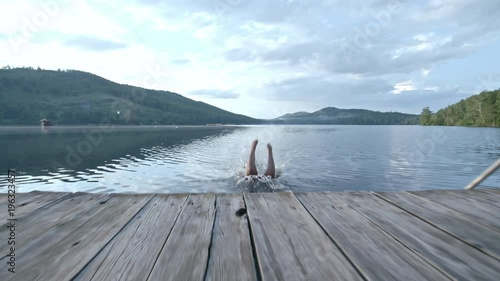 Follow shot of plump black woman running on wooden dock photo