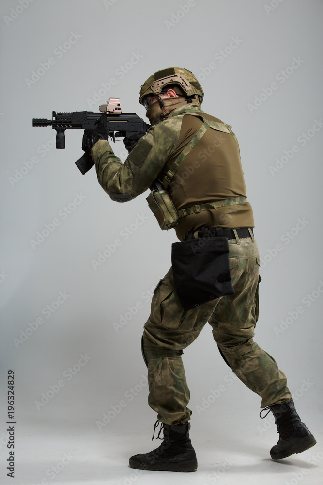 Full-length picture of aiming military man with gun Full-length picture of aiming military man with gun